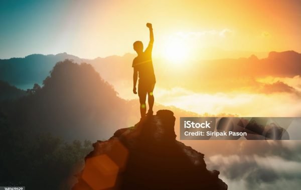 Silhouette of positive man celebrating on mountain top, with arms raised up, silhouette of man standing on the hill, Business, success,victory,leadership,achievement concept. Freedom travel adventure.